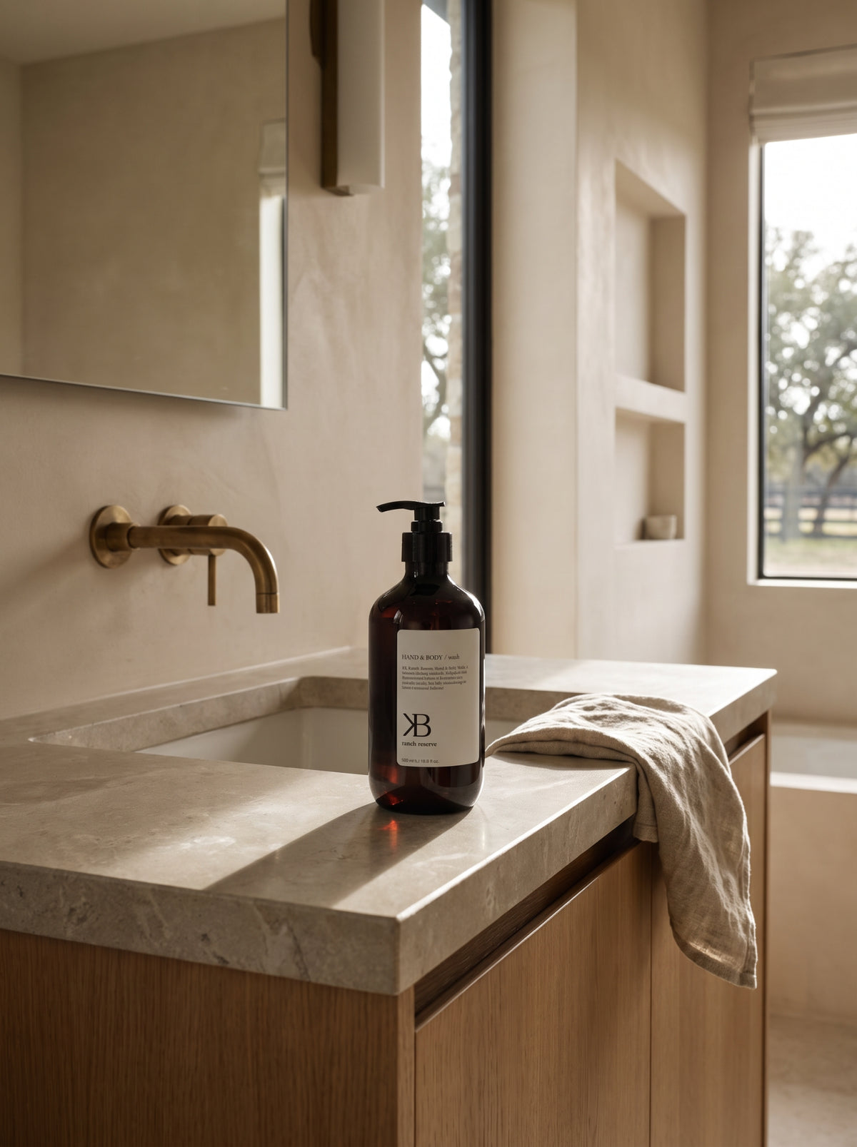 BK Hand & Body Wash beside a folded towel on a stone guest-bathroom counter