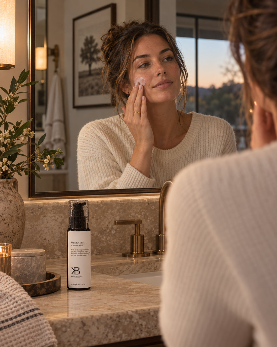 Hydrating Moisturiser on a stone vanity as a woman applies moisturiser at the mirror