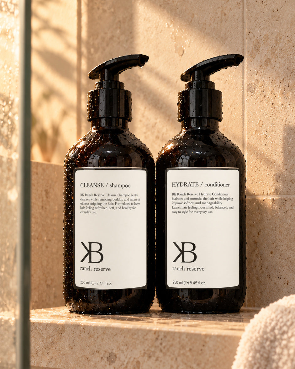 BK Cleanse Shampoo and Hydrate Conditioner together on a sunlit shower shelf
